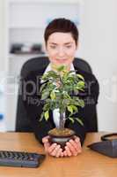 Portrait of a businesswoman looking at a plant