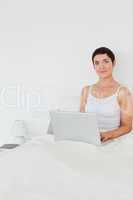 Portait of a dark-haired woman using a laptop