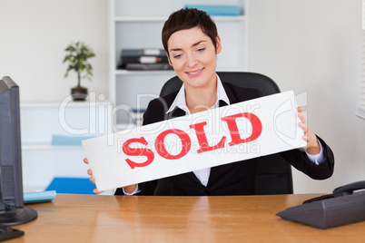Real estate agent with a sold panel
