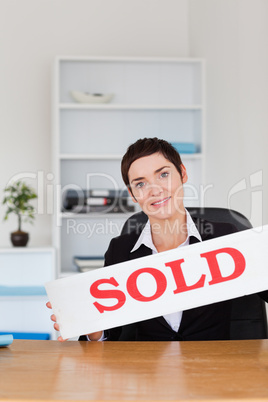 Portrait of a real estate agent with a sold panel