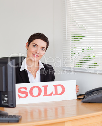 Charming real estate agent with a sold panel
