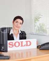 Charming real estate agent with a sold panel