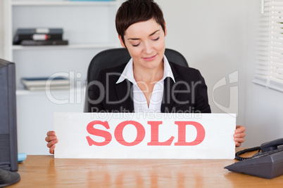 Real estate agent looking at a sold panel