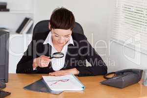 Woman looking at a chart with a magnifying glass