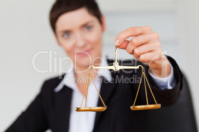 Serious businesswoman holding the justice scale