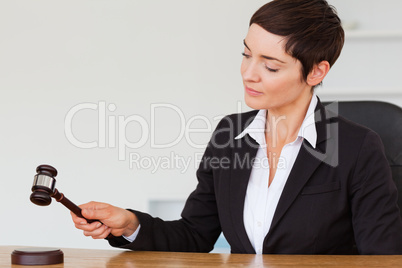 Serious woman knocking a gavel