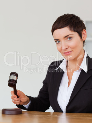 Portrait of a serious woman knocking a gavel