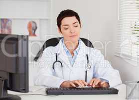 Doctor typing with her computer