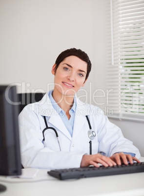 Portrait of a doctor typing with her computer