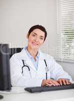 Portrait of a doctor typing with her computer