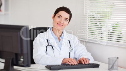 Smiling doctor typing with her computer