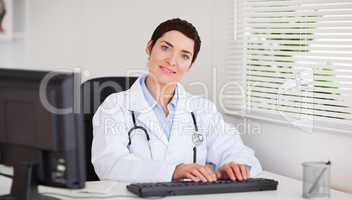 Smiling doctor typing with her computer