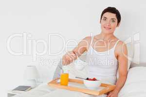 Woman pouring milk into her cereal
