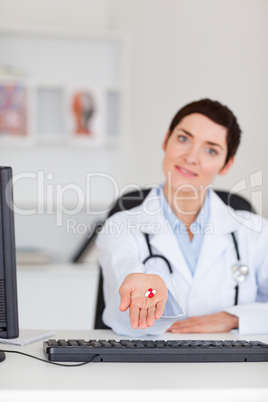 Portrait of a female doctor showing pills