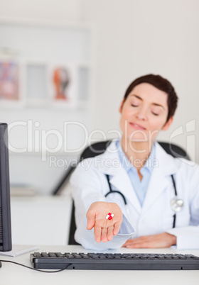 Portrait of a  young female doctor showing pills