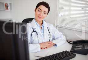 Serious female doctor looking at her computer