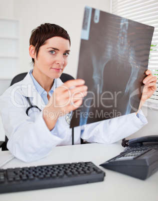 Serious female doctor holding a set of X-ray