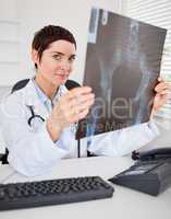 Serious female doctor holding a set of X-ray