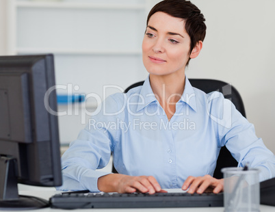 Cute businesswoman typing with her computer