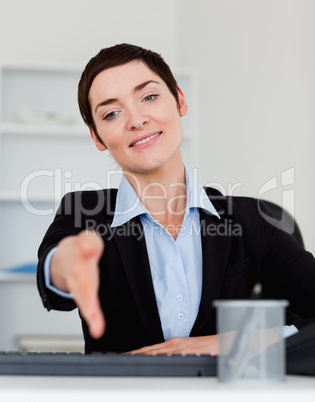 Portrait of a charming business woman giving her hand
