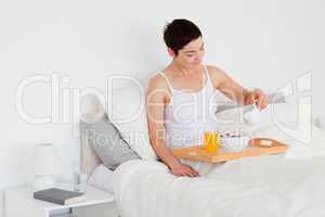 Young woman pouring milk into her cereal