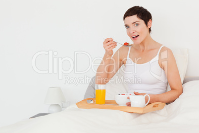 Dark-haired woman eating cereal