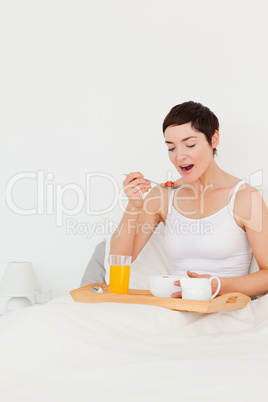 Portrait of a cute woman eating cereal