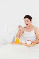 Portrait of a cute woman eating cereal