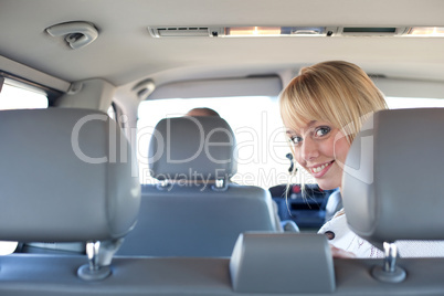 young blond woman on a backseat of a car