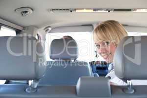 young blond woman on a backseat of a car