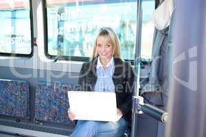 young blond woman with a laptop inside a bus