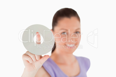 Attractive woman holding a CD while standing