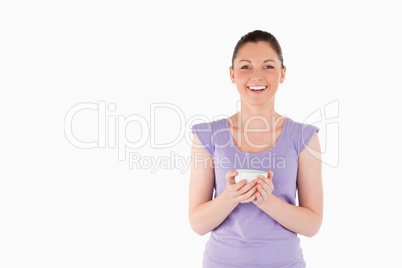 Charming woman enjoying a cup of coffee while standing