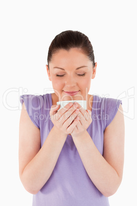 Beautiful woman enjoying a cup of coffee while standing