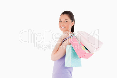 Charming woman holding shopping bags while standing