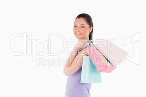 Charming woman holding shopping bags while standing