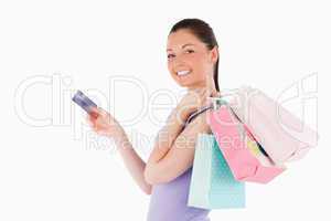 Attractive woman with a credit card holding shopping bags while