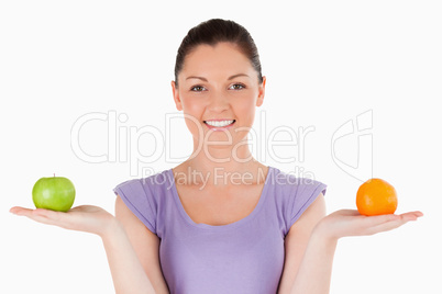 Portrait of a lovely woman holding fruits while standing