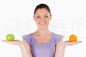 Portrait of a lovely woman holding fruits while standing