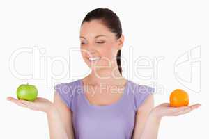 Portrait of a beautiful woman holding fruits while standing