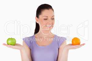 Portrait of an attractive woman holding fruits while standing