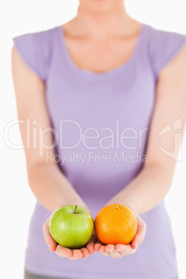 Young woman holding fruits while standing