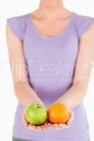 Young woman holding fruits while standing