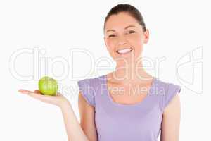 Beautiful woman holding an apple while standing