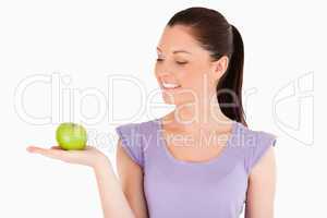 Good looking woman holding an apple while standing