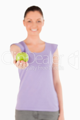 Lovely woman holding an apple while standing