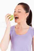 Beautiful woman eating an apple while standing