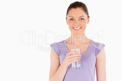 Beautiful woman holding a glass of water while standing