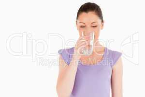 Beautiful woman drinking a glass of water while standing