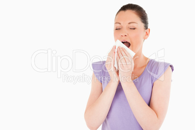 Beautiful woman sneezing while standing